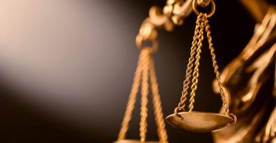 Золотые весы правосудия на размытом темном фоне