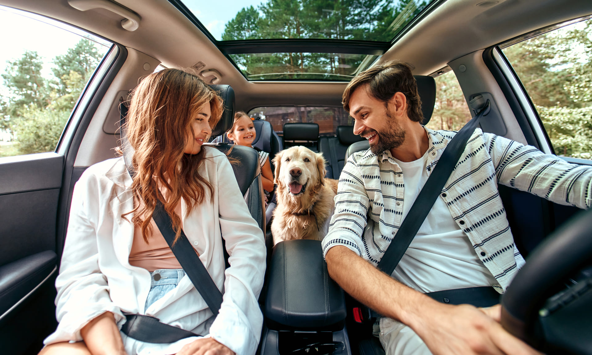 Сім'я з дитиною та собакою їде у власному автомобілі. Вони щасливі, що всі зібрались разом